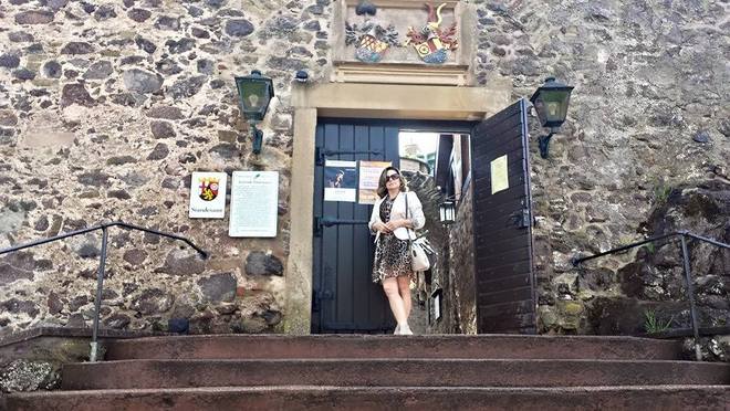 Veronika veste vestido de animal print com blazer branco, sandália cinza claro e bolsa p&b para conhecer a cidade de Idar-Oberstein